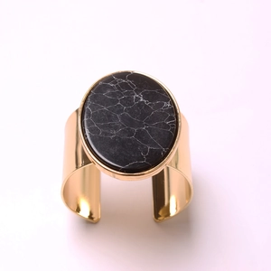 Minimalist gold metal napkin ring with oval black marble stone inlay for hotel table setting