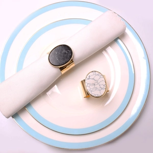 Close-up of marble texture napkin rings with elegant golden metal base for banquet table
