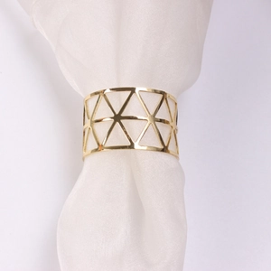 Golden hollow geometric triangle napkin ring on white fabric for wedding table decor