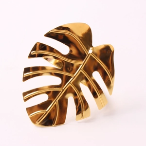 Elegant gold metal monstera leaf napkin ring with a polished mirror finish for table decor