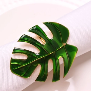 Macro shot of tropical monstera leaf napkin ring with green enamel and gold finish