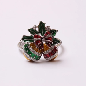 Detail of Christmas napkin ring featuring holly leaves, red bow and jingle bells with rhinestones