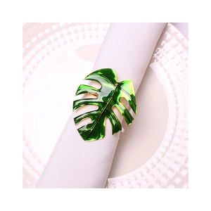 Tropical monstera leaf napkin ring with green enamel and gold edge on a white napkin