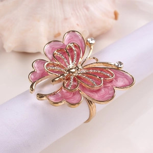 Détail d'un rond de serviette papillon rose avec base dorée et cristaux brillants
