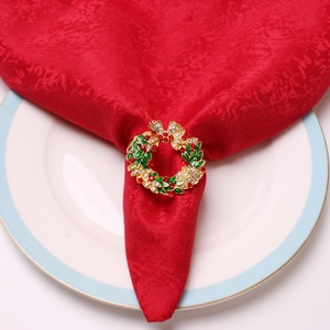 Détail d'un rond de serviette couronne de Noël avec feuilles en émail et cristaux rouges