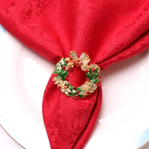 Détail d'un rond de serviette couronne de Noël avec strass sur une serviette rouge