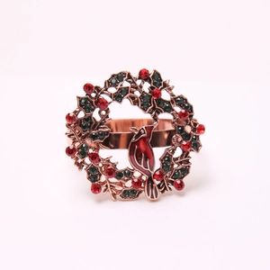 Macro detail of Christmas napkin ring featuring a festive red bird and green wreath design