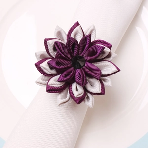 Handmade purple lotus fabric napkin ring with crystal center on a white plate