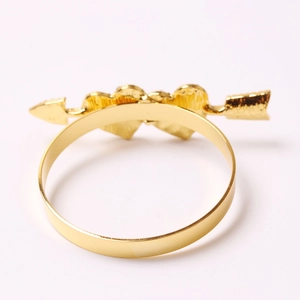 Golden heart-shaped napkin ring with hammer texture and cupid arrow design on white background