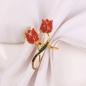 Detail of tulip napkin ring with red and green rhinestones on white fabric
