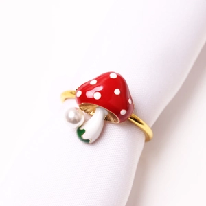 Red mushroom napkin ring with white dots, pearl detail and golden zinc alloy finish