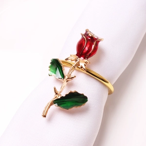 Elegant gold rose napkin ring with red enamel flower and rhinestone on white linen