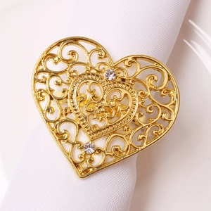 Macro detail of golden heart napkin ring with hollow pattern and sparkling rhinestones