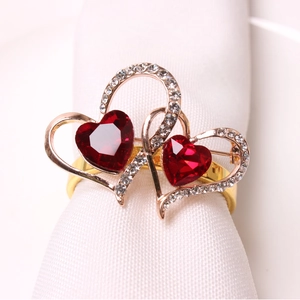 Detail of red heart napkin rings with crystal accents for wedding table setting decor