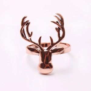 Detail of rose gold reindeer head napkin ring showing metallic gloss and antler texture