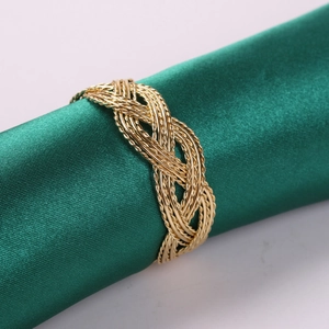 Detailed view of gold woven metal napkin ring with elegant braided rope texture