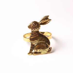 Golden bunny napkin ring with detailed fur texture on a minimalist white background