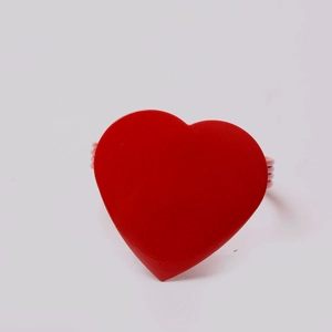 Close-up of a glossy red heart napkin ring with a pink spiral wire coil base