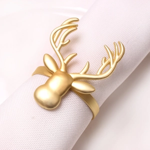Golden reindeer head napkin ring on white linen, festive holiday table decoration