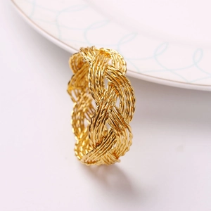 Golden woven mesh napkin ring with intricate braided texture for elegant table decor