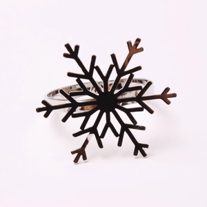 Macro shot of silver metal snowflake napkin ring with intricate cutout hexagonal design