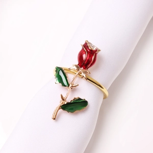 Elegant red rose napkin ring with golden alloy stem and crystal detail on white fabric