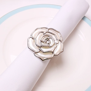 Silver rose napkin ring with white pearl petals on white napkin and ceramic plate