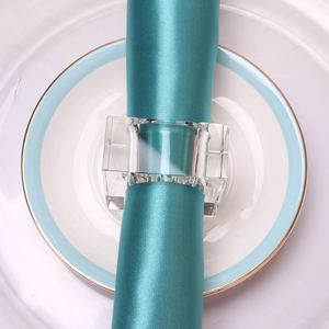 Modern square crystal napkin ring with round center hole on blue satin napkin and white plate