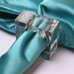 Macro detail of clear square acrylic napkin ring with blue satin fabric insert