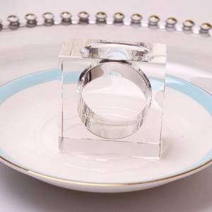 Macro shot of square clear crystal napkin ring on a decorative ceramic dinner plate