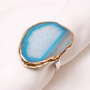 Blue natural agate napkin ring with gold trim on white linen for elegant table decor