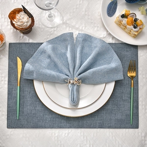 Elegant gold LOVE napkin ring with pearls and rhinestones on light blue linen napkin