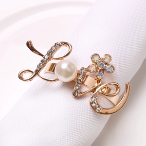 Elegant gold LOVE napkin ring featuring a large pearl O and sparkling rhinestone accents