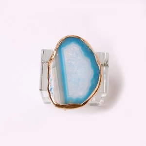 Detailed view of blue agate napkin ring with gold plating on crystal stand