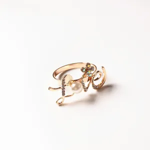 Detailed view of a gold-plated LOVE ring featuring a pearl and colorful rhinestones
