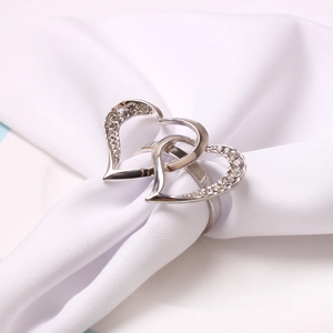 Silver double heart napkin ring with sparkling rhinestones on a white linen napkin