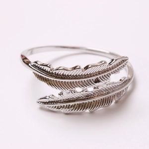 Silver double feather napkin ring with intricate carved texture on metal surface