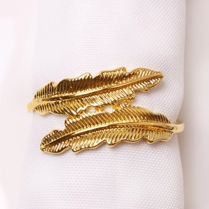 Elegant gold double feather napkin ring with polished metal finish for dining decor