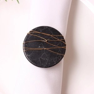 Handmade marble stone napkin ring with gold wire wrapping on a white fabric napkin