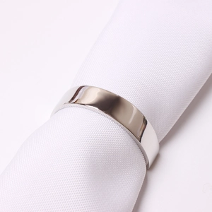 Détail d'un rond de serviette semi-circulaire poli sur fond de tissu blanc