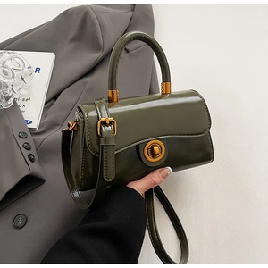 Close-up of olive green crossbody bag with shiny finish and round gold metal turn-lock