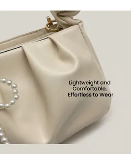 Detailed close-up of cream pleated shoulder bag featuring elegant pearl bead accessory