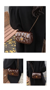 Détail du sac bandoulière matelassé marron foncé avec chaîne dorée et fermoir rotatif