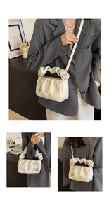 Detail of off-white pleated cloud bag featuring pearl bow and silver heart pendant