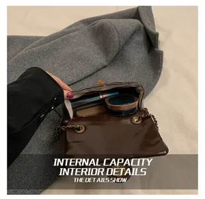 Détail de l'intérieur du sac matelassé à chaîne contenant du rouge à lèvres et du maquillage