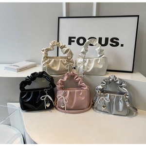 Detail of ruched cloud bags in five colors with pearl bows and heart pendants