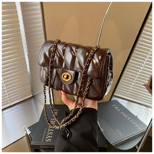 Détail du sac bandoulière en cuir matelassé marron foncé avec chaîne dorée et fermoir