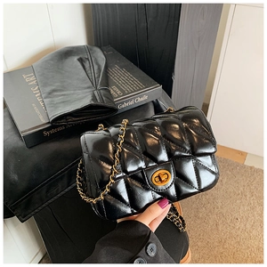 Détail du sac bandoulière matelassé noir avec fermoir rotatif doré et bandoulière chaîne