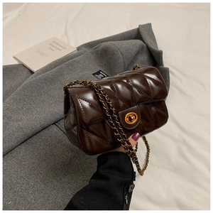 Détail du sac matelassé marron foncé avec chaîne dorée et fermoir rotatif en métal