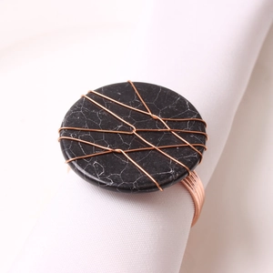 Handmade marble napkin ring with rose gold wire wrap on white fabric napkin